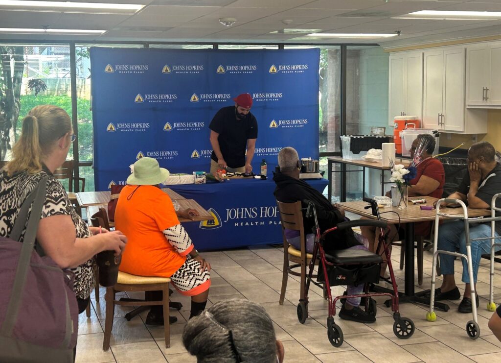 Chef Giacomo Sciuto prepares a healthy dish during a live cooking demo for residents at Bowman Place, hosted by Johns Hopkins Advantage MD.