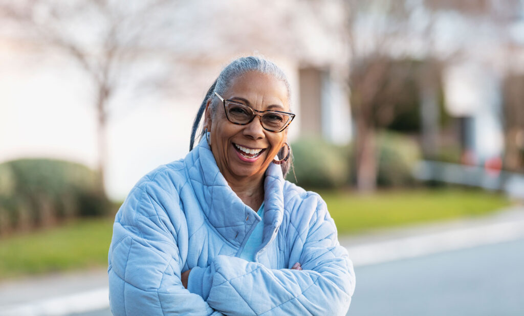 Mature woman wearing a blue coat outside on a nice Fall day